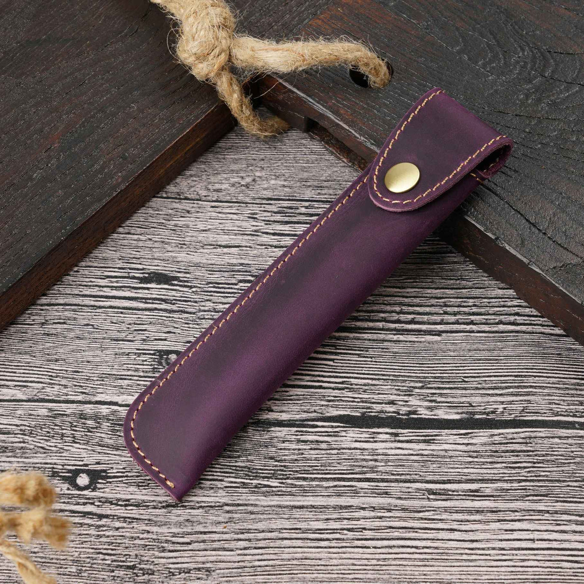 Leather pen pouch lying flat with the snap closure visible
