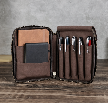 Leather pen case holding five pens with an A6 notebook and phone pocket