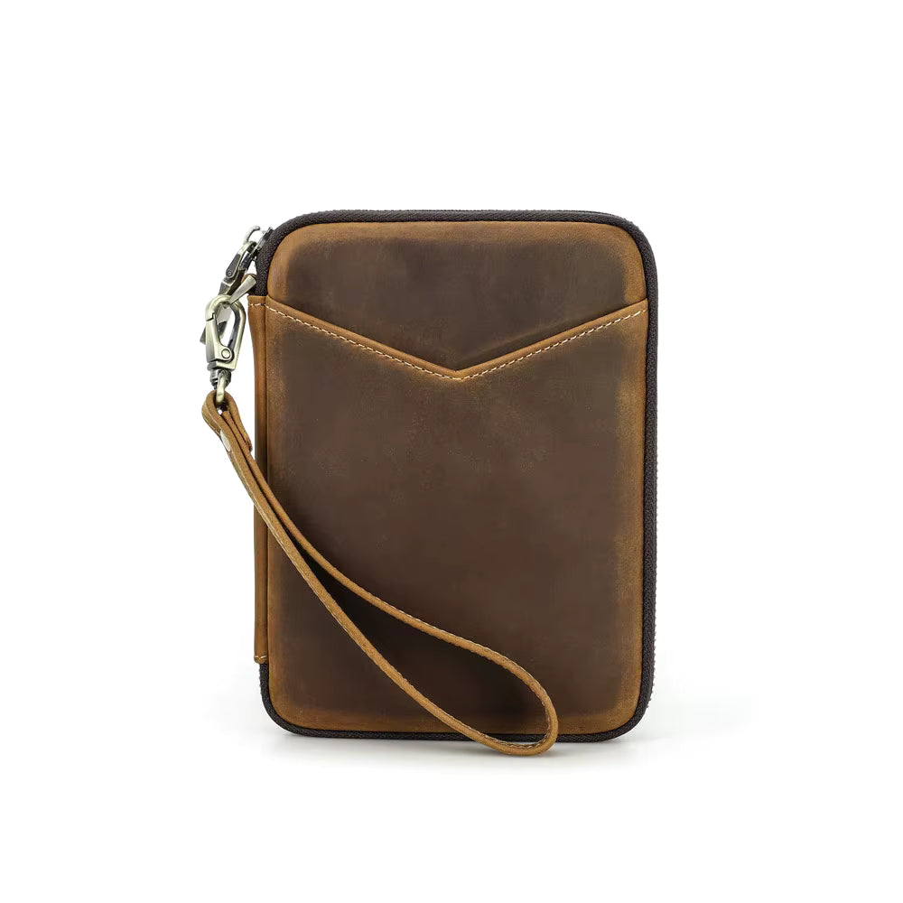 Closed leather pen case organizer displayed with five pens, notebook, and phone