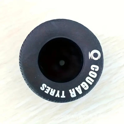 Decorative tire pen container beside a notebook on a desk